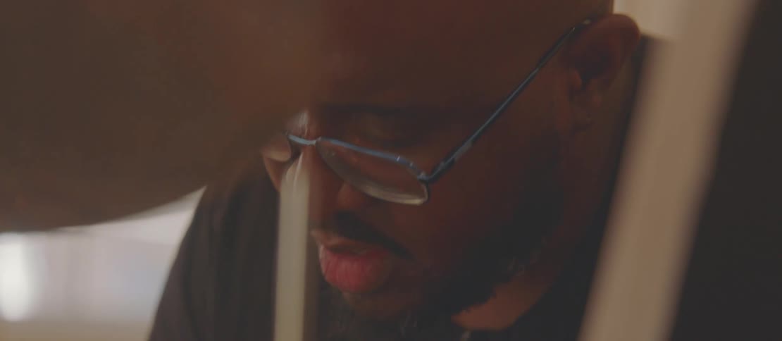 Man concentrating on a sheet of paper on top of a musical drum