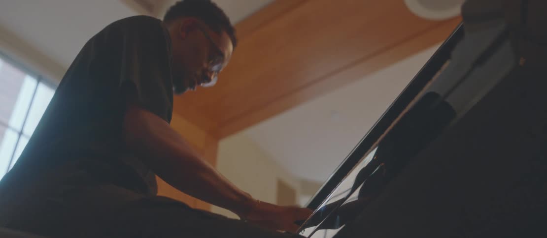 Upward view of a seated man playing the piano