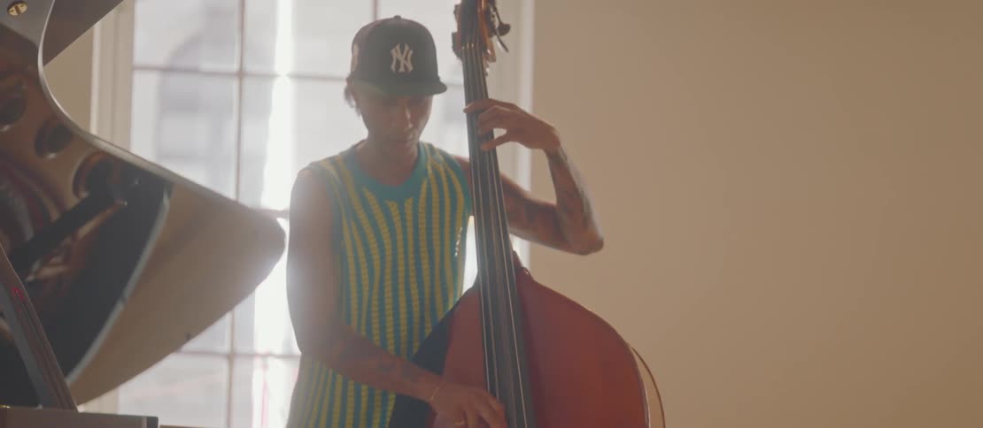 Three male musicians play instruments together enjoying the music