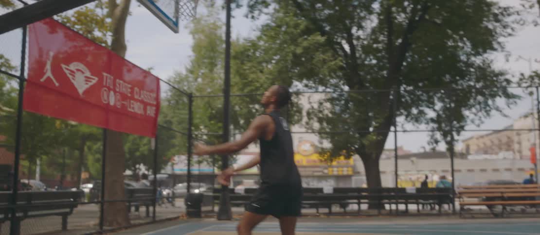 Two men play basketball on an outdoor basketball court
