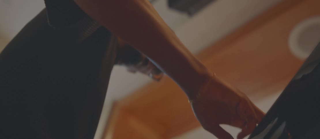 A man is playing a grand piano