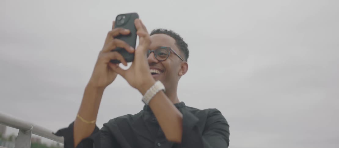 Cheerful man interacting and filming with his iphone
