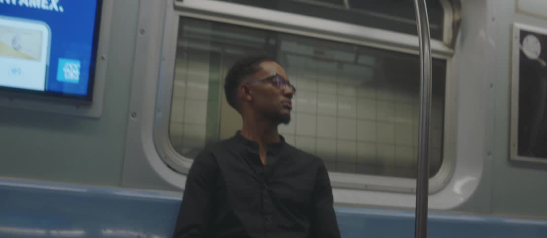 A clip of a black male sitting in a public transit