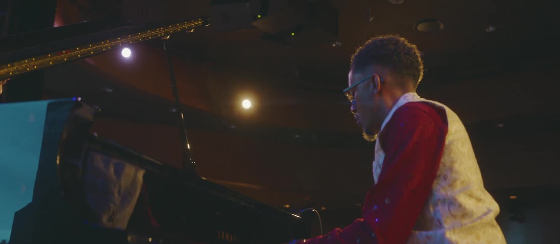 Man playing piano in a performance in an auditorium