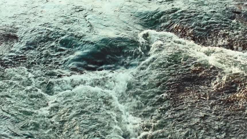 A stream with a small elevation under the water with the water passing over a relief quickly