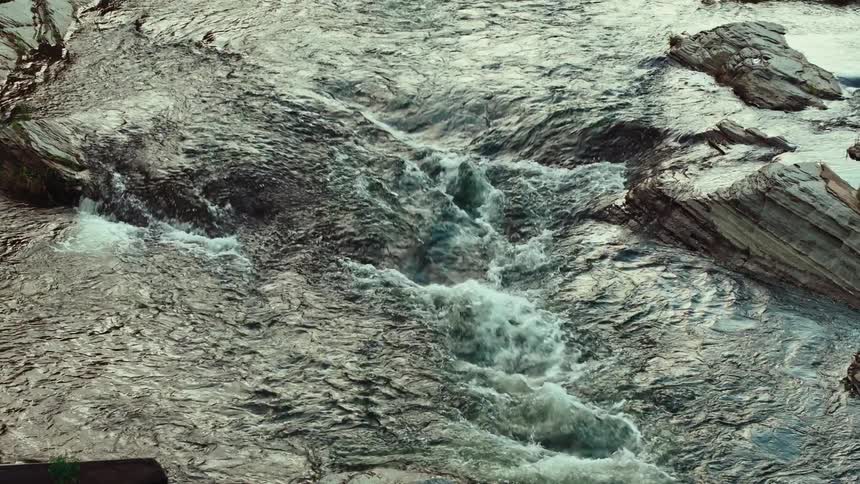 A small river with a strong current among rocks