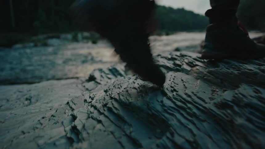 Walking over slippery rocks on a rivers edge