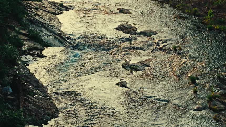 A river runs through multiple small rocky rapids