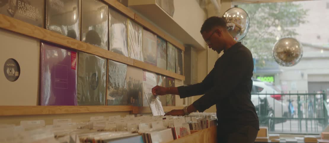 A black male looks at records inside of a store