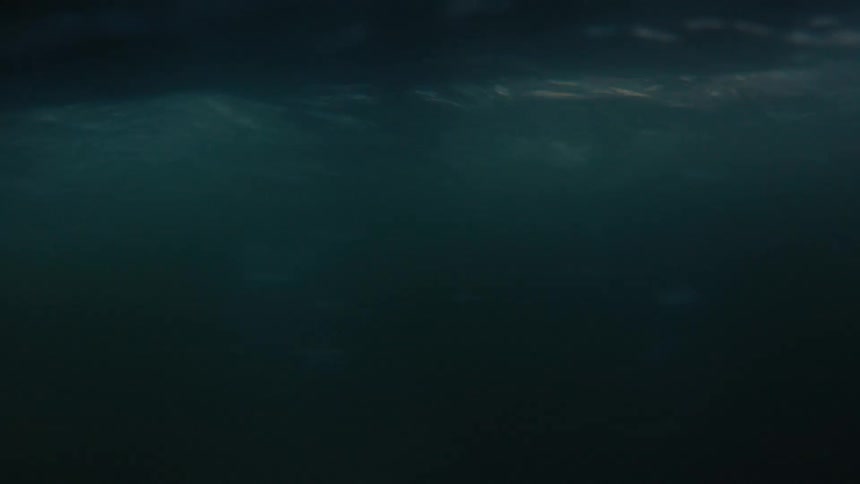 Closeup beneath the surface of murky flowing water