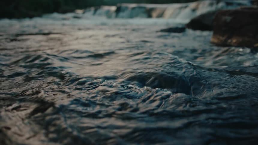 Water pours over a rapid and burbles closer to shore