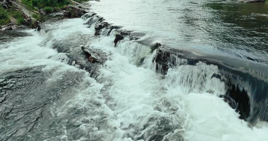 A river drops over rocky rapids in nature
