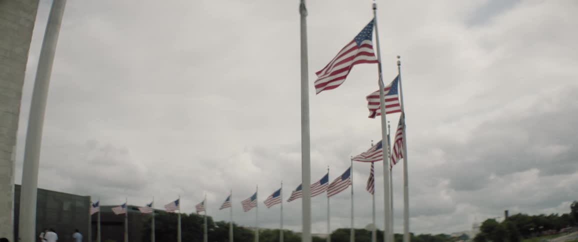 People visit the washington monument on an overcast summer day