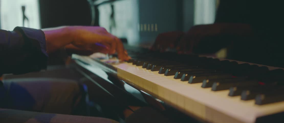 Closeup of a pianists hands in motion on a grand piano keyboard