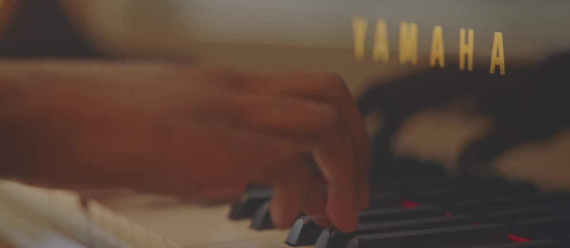 A black male plays the piano