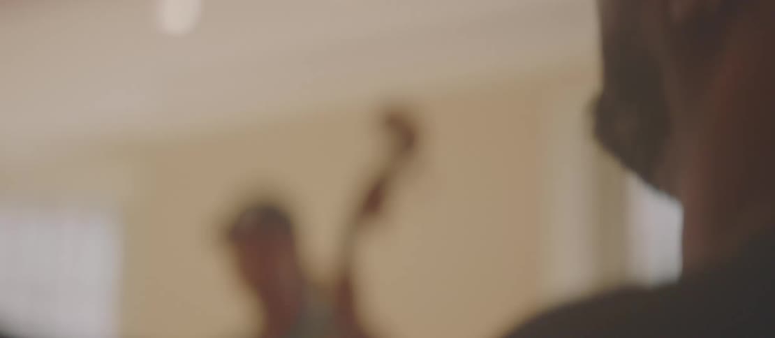 A black man plays drums with a man playing a stand up bass in a room