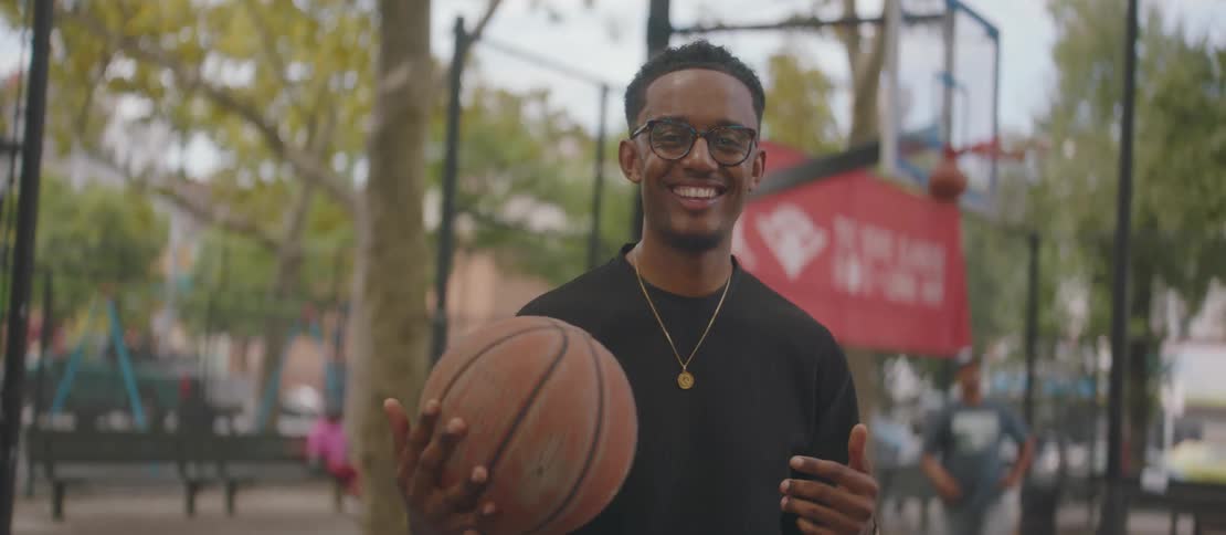 Young smiling man holding a basketball