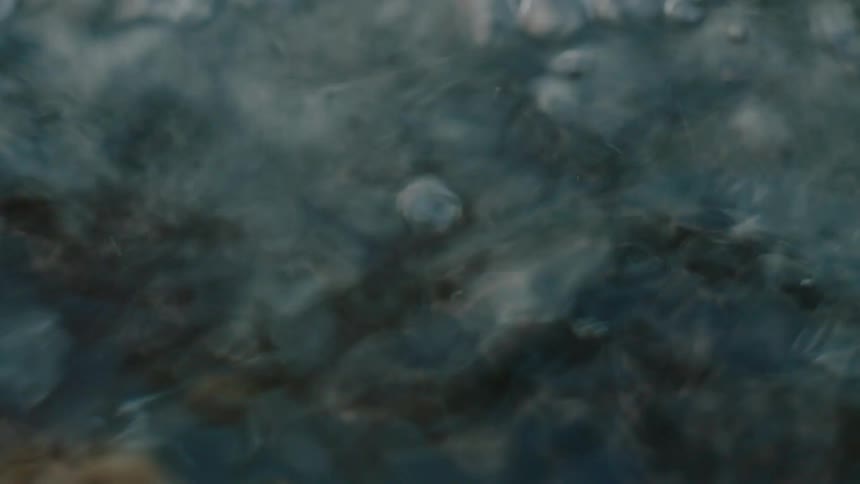 Moving river water surface with bubbles