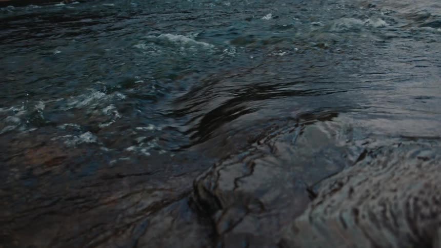 Waters of a river flowing beside rocks