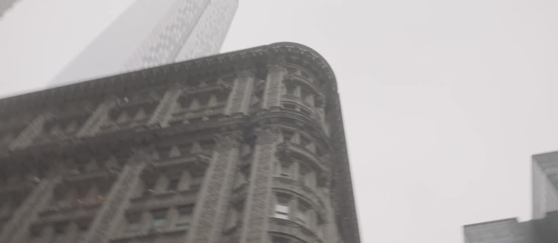 Some tall buildings of a metropolitan city seen from below and the sky is white with fog