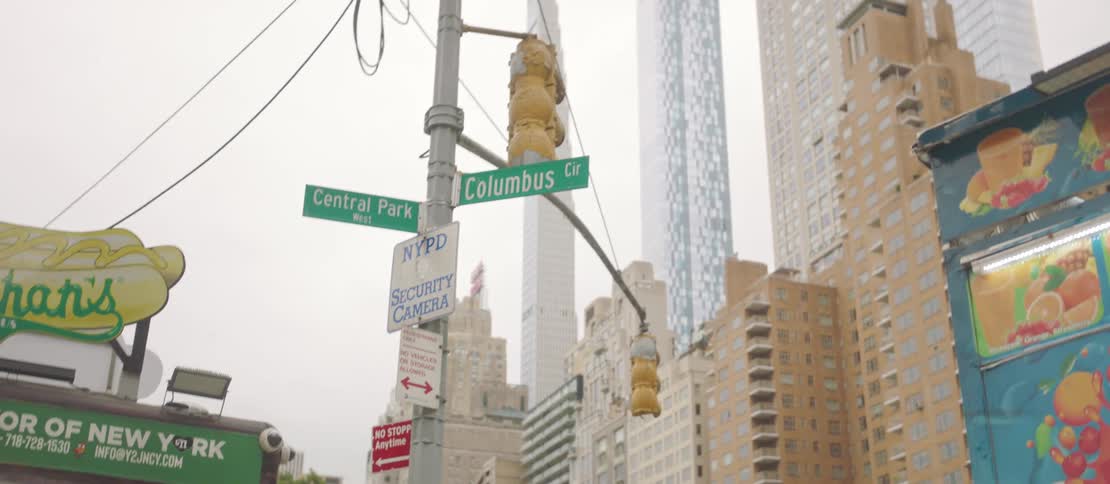 Street signs on a pole near a restaurant in a downtown city area