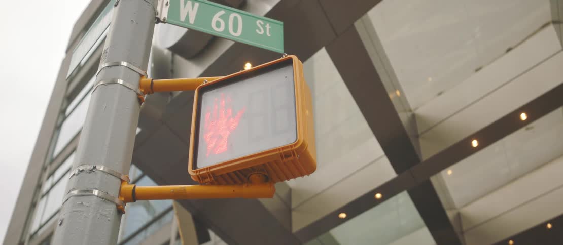 A clip of a traffic light and a street sign pole