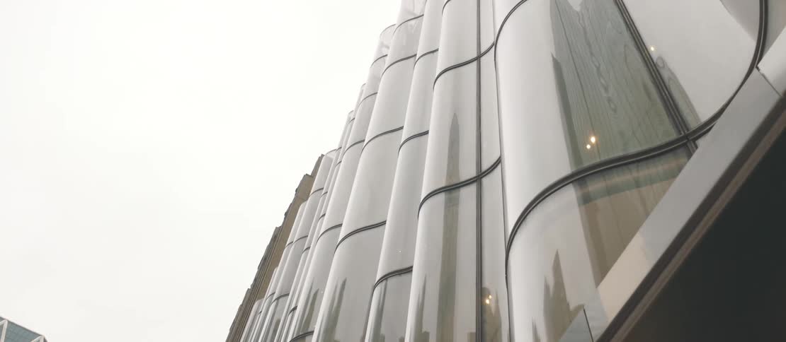View up a modern mirrored building on a cloudy day