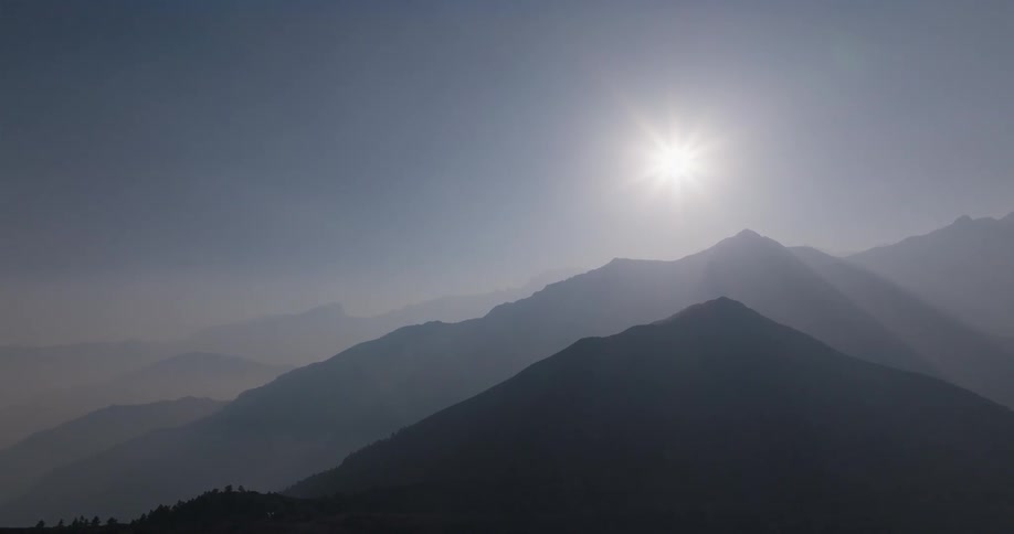 Aerial scene of mountains with the sun on the horizon