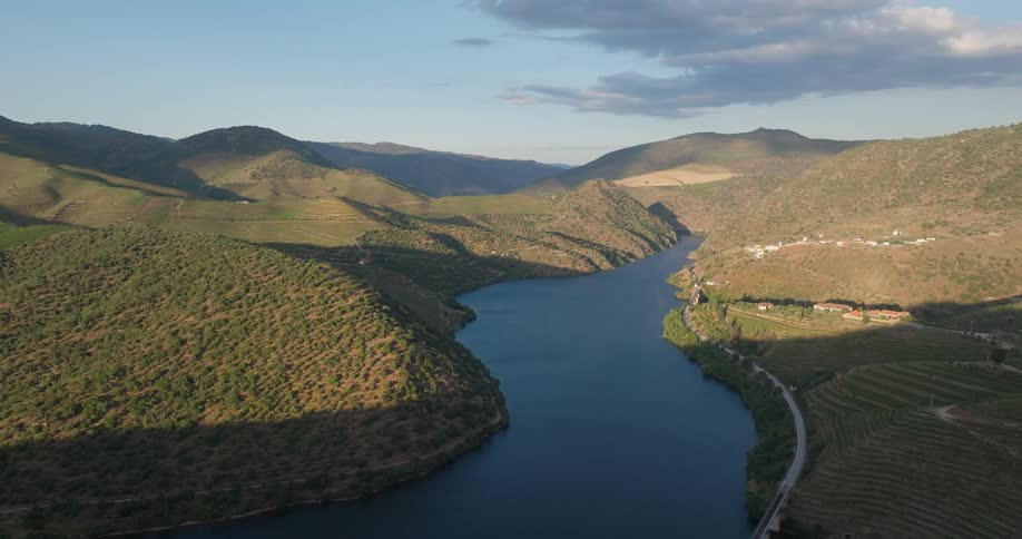 A huge river between several flat grassy hills seen from above