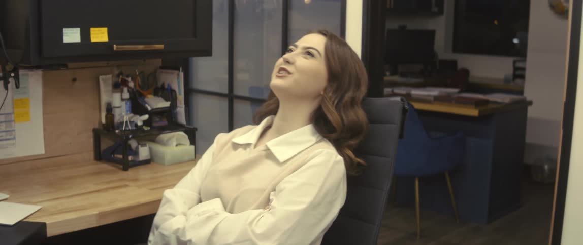 Woman sitting on a chair celebrating happily in an office environment