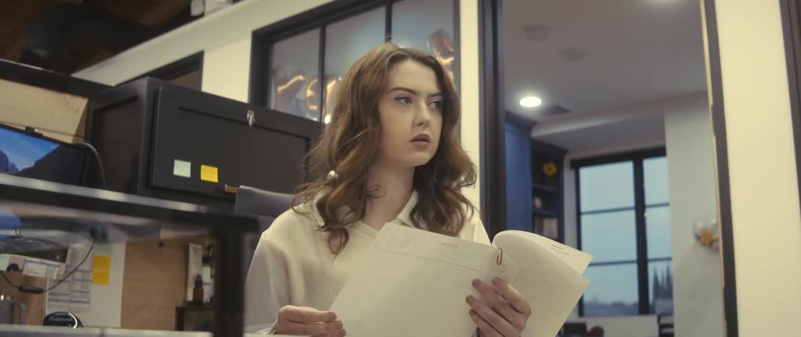 Woman sitting in an office environment looking at a document