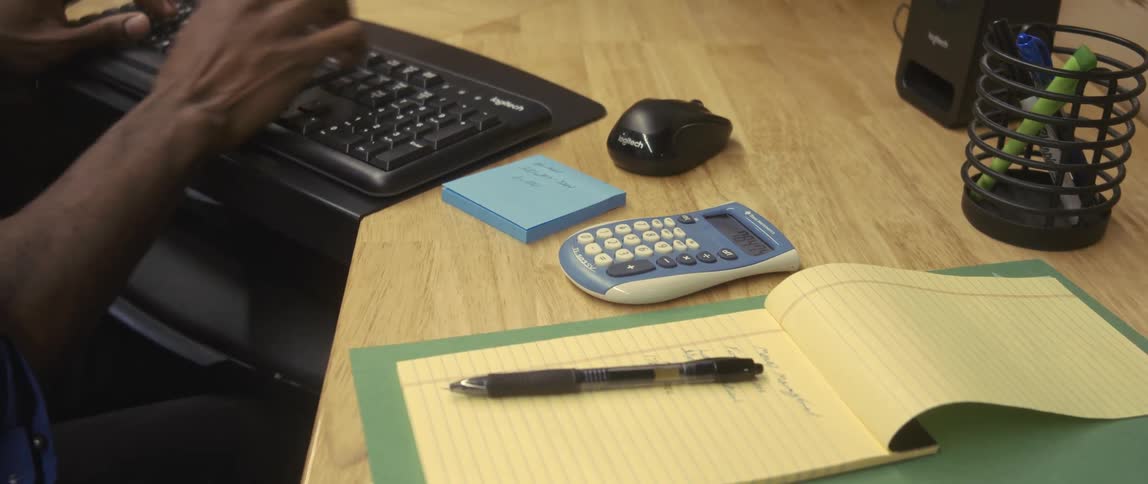 A man is typing on a keyboard in the office