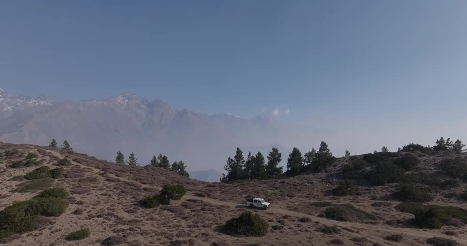 An atv driving on a dirt road at the top of a mountain
