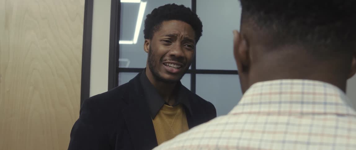 Coworkers have a conversation in the hallway