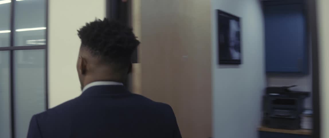 A man walks into the office and talks with a coworker