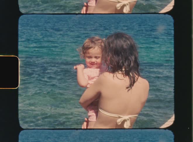 Super 8 film of a mother who is holding her daughter by the sea