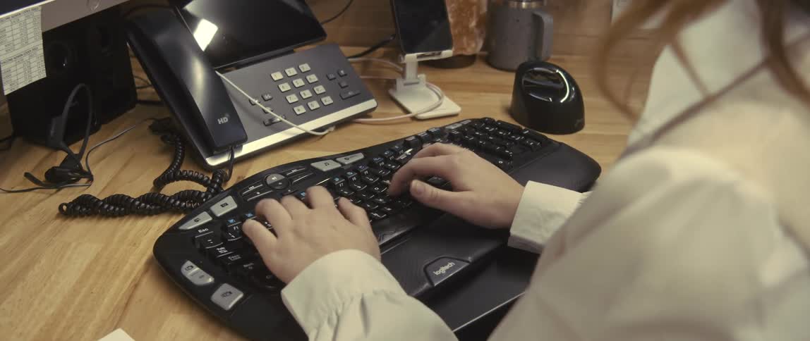 Hands of a woman typing on a keyboard