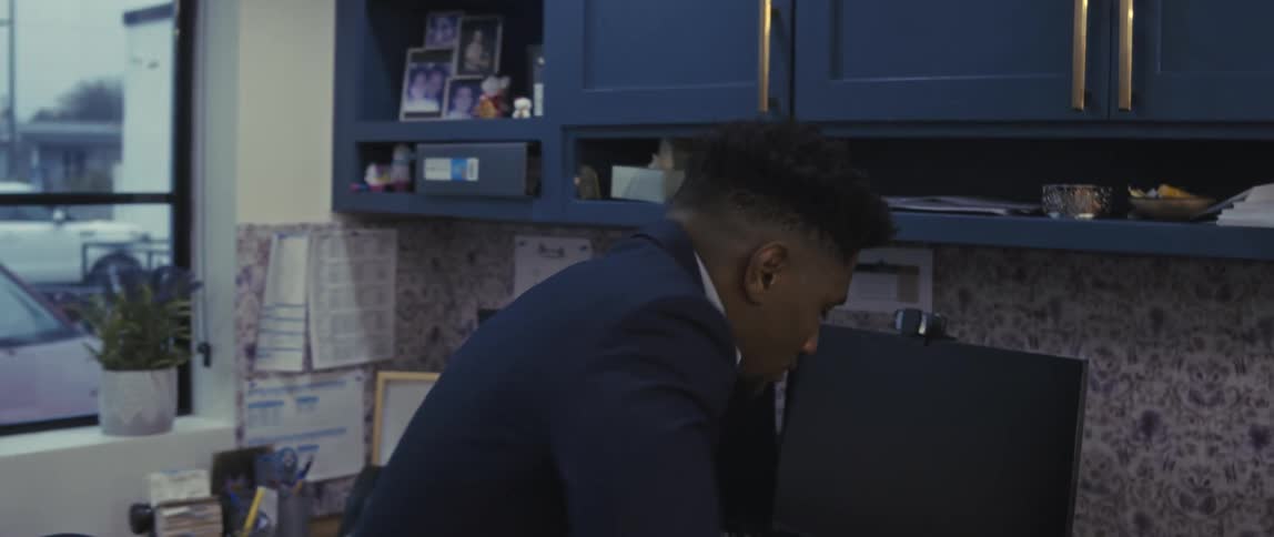 A man walks into his office and sits down at his desk