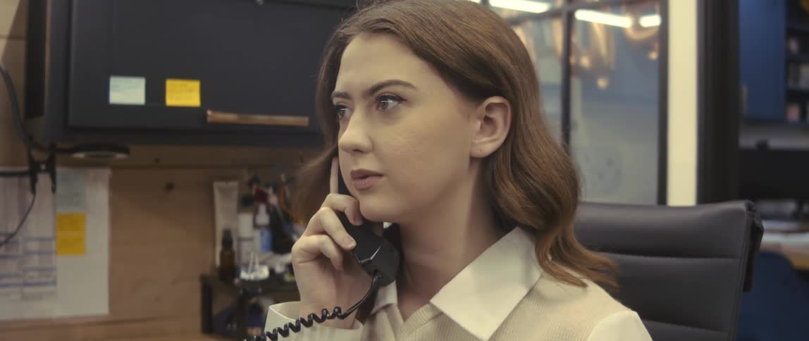 Woman talking on the phone sitting at an office desk