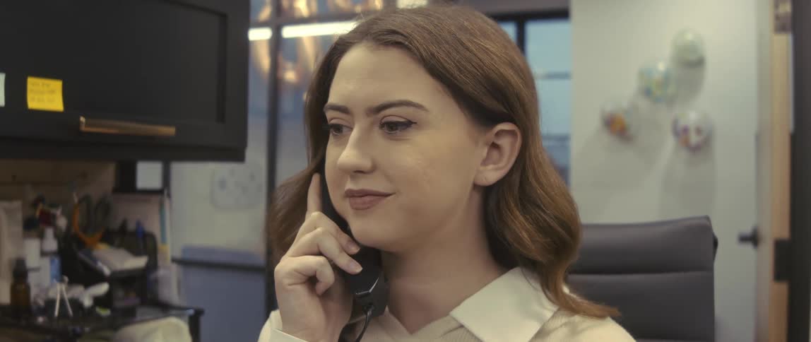 Portrait of a woman sitting in an office room talking on the phone