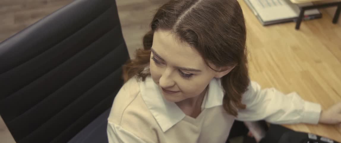 Woman sitting at an office desk looking to the side