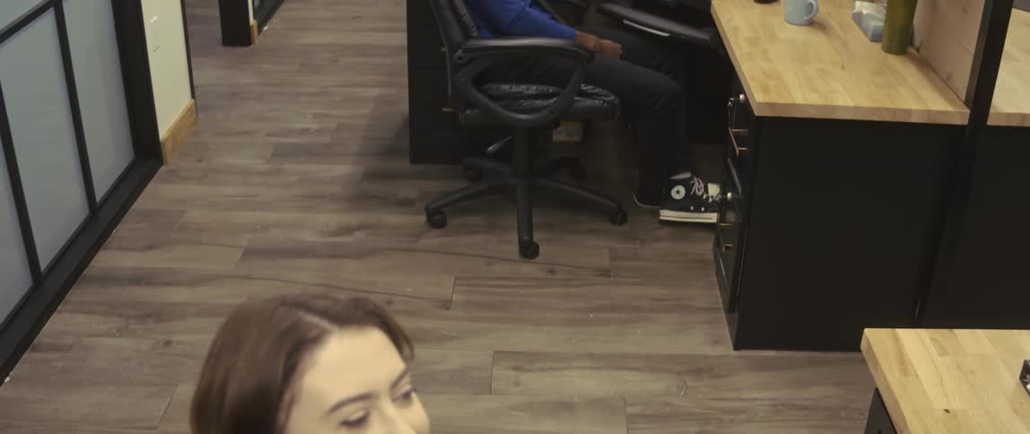 A woman and man work the phones in office cubicles