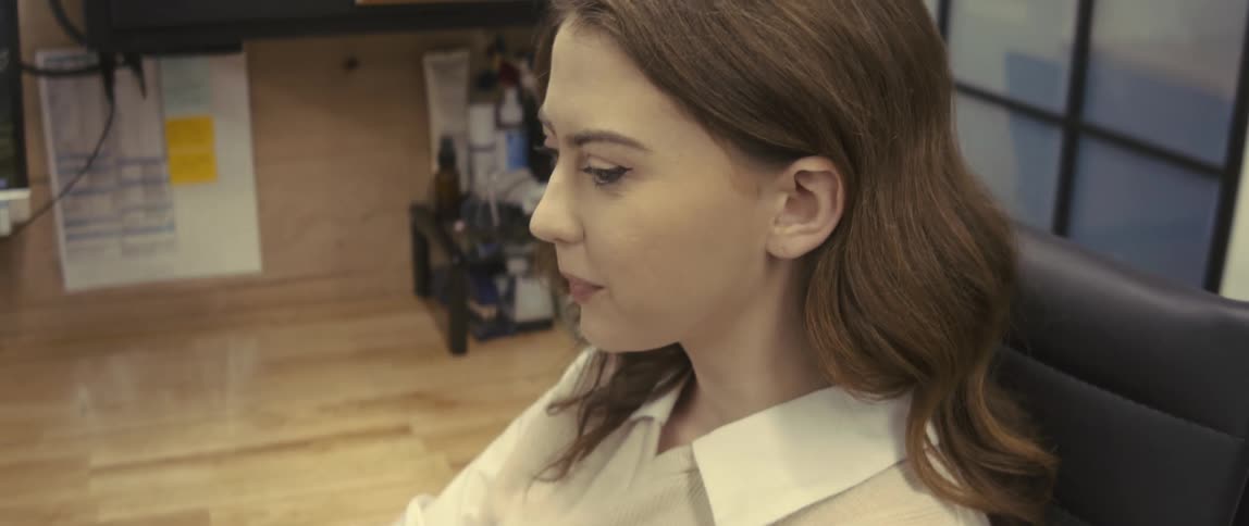 Portrait of a woman sitting at an office desk interacting with the computer