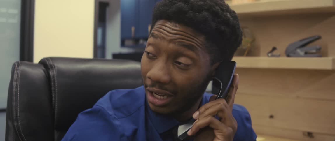 A man is talking on a phone in the office
