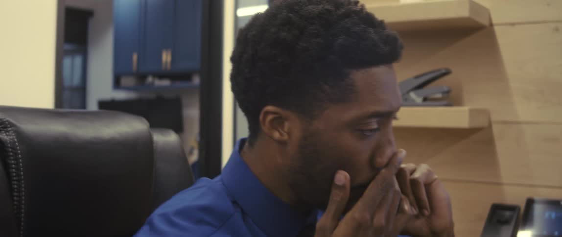 Man sitting in an office environment talking on the phone