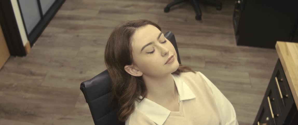 A woman rests and types on her keyboard in the office