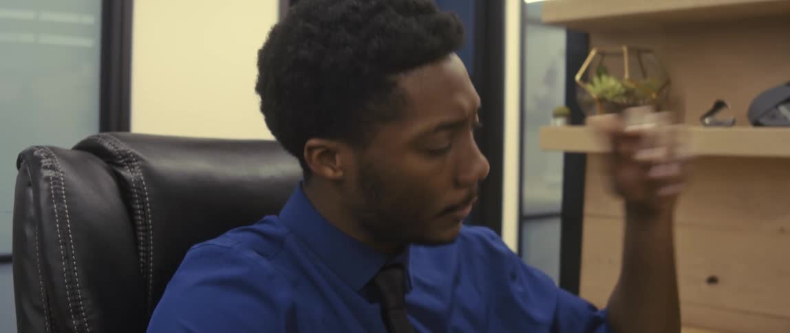 A stressed businessman talks on the phone and becomes saddened upon hearing bad news at the office