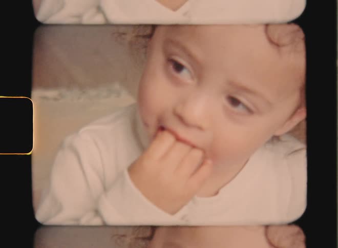 A child is eating and licking chocolate off her fingers, captured on Super 8 film