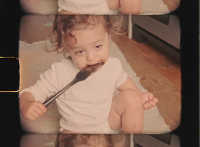 Super 8 film of a toddler who scoops a spoonful of food from a large baking bowl