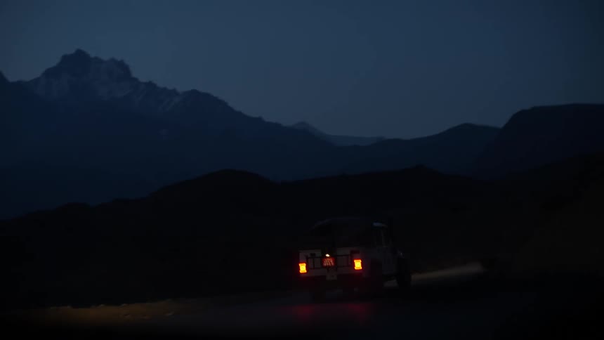 Car driving toward the mountains at night